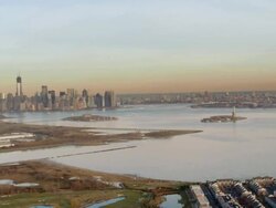 Aerial view of lower Manhattan and Statue of Liberty in the late afternoon Stock Footage