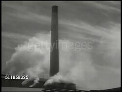 1940: SWEDEN: WS Apartment buildings w/ neatly stacked firewood rows in field FG. WS Hedge, apartments BG. PULP INDUSTRY: LA WS Factory tall stack w/ smaller stacks w/ white smoke. Automated log stripper. Paper pulp on conveyor, out of chute, into vat Instructional Video