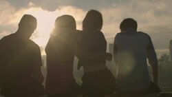 Group of friends hug and take smartphone photos over city skyline Stock Footage