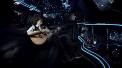 Rockstar waves to fans and strums guitar in back of limousine at awards show Stock Footage
