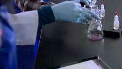 Teacher assists students using tablet to conduct lab Stock Footage