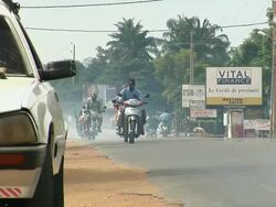 MS, Motorcycles and cars on small town road, Porto-Novo, Benin Stock Footage