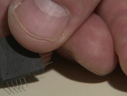 Close Up_static - Fingers hold a tiny computer chip.   Stock Footage