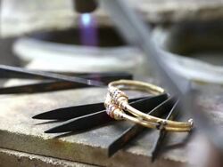 Goldsmith Jeweler use gasoline burner melting and decorating bracelet Stock Footage