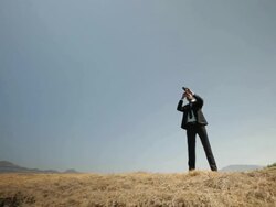 Businessman watching mountains through day telescope  Stock Footage