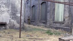 American World War 2 GIs advance through industrial buildings Stock Footage