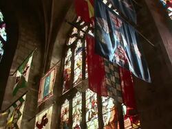 PAN Banners hanging in the light from stained glass window inside cathedral / Edinburgh, Scotland, United Kingdom Stock Footage