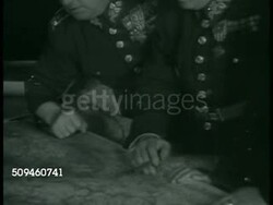 1938: PRAGUE, CZECHOSLOVAKIA: Prague Castle entrance, guard patrolling. General Jan Syrovy (eye patch) standing w/ other officers looking at table map. CU Map w/ pins in Berlin. Silhouette of statue. WS Charles Bridge, Vltava River, seagulls FG. Instructional Video