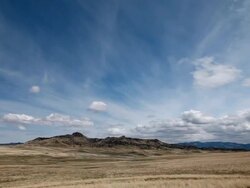 WS View of Dramatic clouds on prairie with Rockie Mountains in back side and sun and shadows rolling across landscape / Augusta, Montana, United States Stock Footage