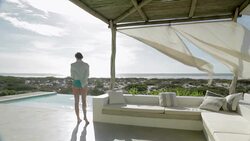 Woman photographing view on luxury patio overlooking ocean Stock Footage
