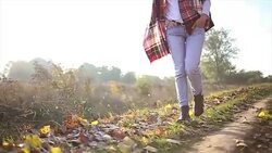 Woman walking through autumn leaves on ground Stock Footage