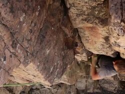 Handheld tilt of a rock-climber hanging from a rope. Stock Footage