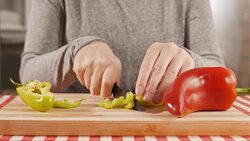Woman slicing yellow bell pepper on cutting board, close up Stock Footage