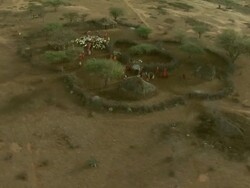 Wide Shot - Maasai wear colorful attire as they gather in their village / Kenya Stock Footage