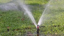 Water sprinkler showering grass.  Part 1 Stock Footage