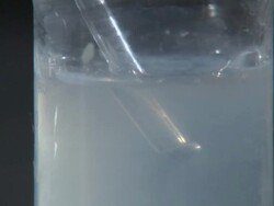 Lime water test for carbon dioxide. Carbon dioxide gas bubbling through lime water (calcium hydroxide solution), which turns milky as the gas reacts to form a precipitate of calcium carbonate Stock Footage