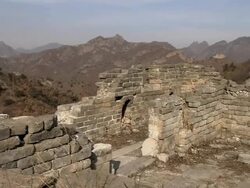 A tower of the Great Wall of China that has crumbled, with arid mountains in the background.   Stock Footage