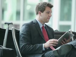 MS Well dressed young businessman using tablet device inside airport / Minneapolis, Minnesota, United States Stock Footage