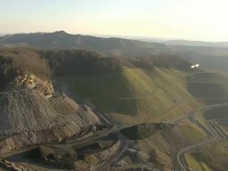 Wide Shot aerial push,in , Dirt roads wind along the perimeter of a strip mine. / West Virginia Stock Footage