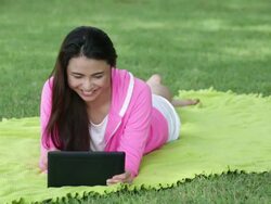 MS Happy young woman playing with a digital tablet in a park. Stock Footage