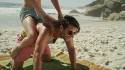 Young couple playing on beach Stock Footage