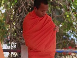 MS TU SLO MO Buddhist monk demonstrating folding and putting on safran robe / Vientiane, Laos Stock Footage