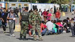 Greek soldiers guard Syrian migrants fleeing the war and escaping to Europe, who have landed on the Greek island of Lesvos on the north coast at Efthalou. Up to 4,000 migrants a day are landing on the island and overwhelming the authorities. They are trafi Stock Footage