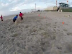 A group of young men playing flag football on the beach. - Slow Motion Stock Footage