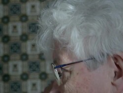 Elderly woman putting on glasses Stock Footage