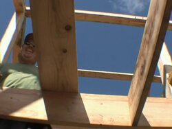 WS ZO Carpenter helping to put wood plank in place while framing an energy efficient post / Grass Lake, Michigan, USA     Stock Footage