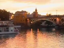 Tour Boat Passing Under Bridge on Guadalquivir River Seville Spain Stock Footage