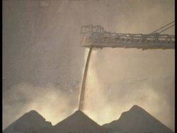 MS Sand from mine poured on pile, dust reflects afternoon light Stock Footage