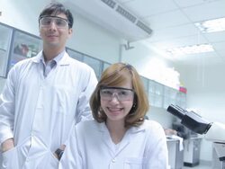HD : Scientist Couple using microscope [Zoom In] Stock Footage