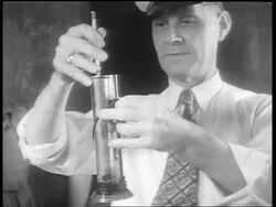 B/W 1932 man with hat testing whiskey with device / whiskey production / Louisville, KY Stock Footage