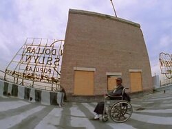 Fisheye low angle senior Black man in wheelchair moving around on roof to camera smiling / Los Angeles, CA Stock Footage