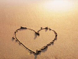 Heart drawn in sand, washed away by ocean Stock Footage