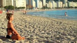 Brazilian girl practices yoga on Copacabana Beach Stock Footage