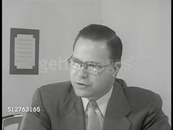 1953: LEVITTOWN, PENNSYLVANIA: DRAMATIZATION: 'Principle Joseph Roberts' (SOT) explaining this is temporary location for elementary school, giving folder to mother to help w/ orientation. Instructional Video