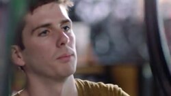 Customer watches as bike mechanic places wheel on truing stand in repair shop Stock Footage