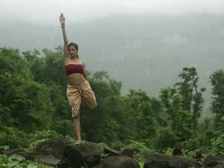 Young woman practicing yoga in the forest, Malshej Ghat, Maharashtra, India Stock Footage
