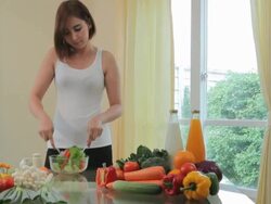 Happy woman cooking vegetables green salad Stock Footage