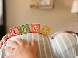 A pregnant women using blocks to spell the word LOVE on her stomach. Stock Footage