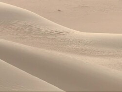 Wide Shot, pan-right - Sand dunes form unique shapes in the Sahara Desert in Egypt Stock Footage