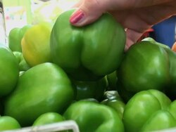 Woman's hands checking quality of some green peppers at market Stock Footage