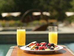hotel resort lodge pool deck deck chairs guests bathrobes breakfast fruit bowl orange juice holiday vacation getaway Stock Footage