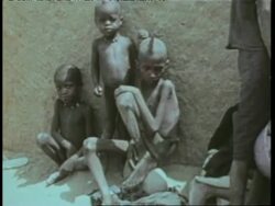 Starving children sit beside a wall in Africa. News Clip