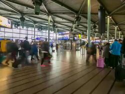 HD time-lapse zoom out: Traveler Airport station Terminal Schiphol Amsterdam Netherlands Stock Footage