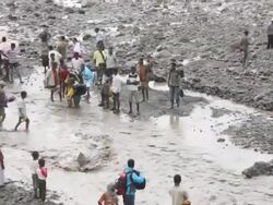People crossing river following bridge collapse Stock Footage