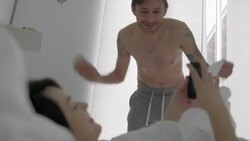 Young man sets coffee down and jumps back into bed with girlfriend Stock Footage