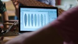 Wood shop workers collaborate on skateboard design in team meeting Stock Footage